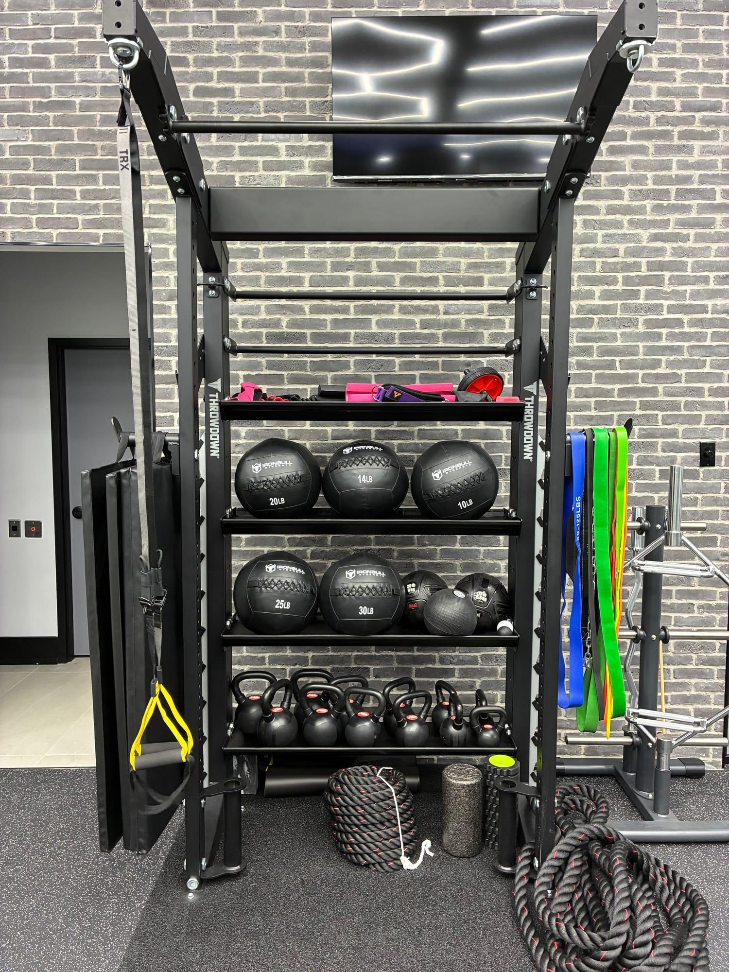 Functional training rack with medicine balls, kettlebells and battle ropes