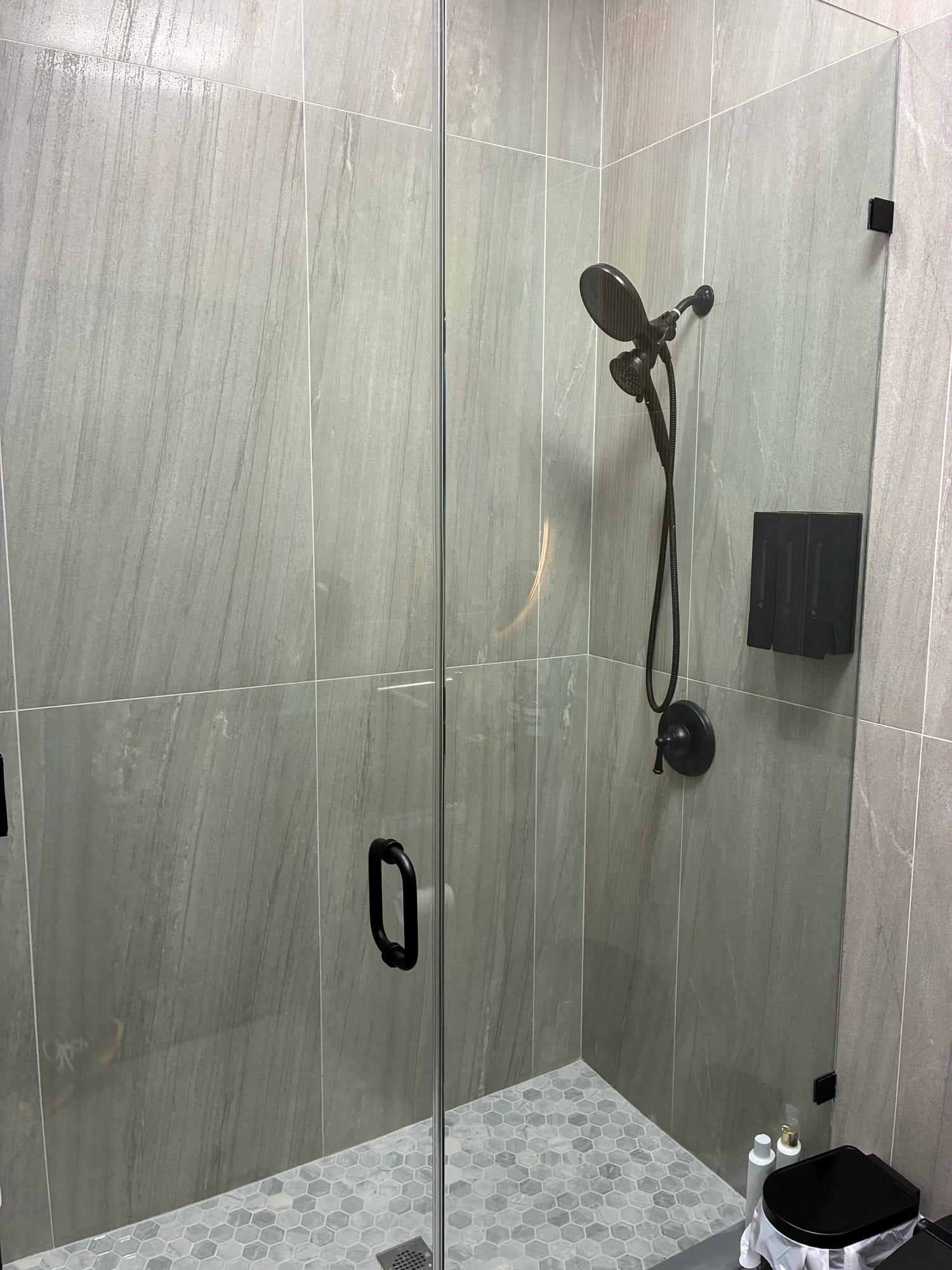 Glass-enclosed shower with stone-look tile