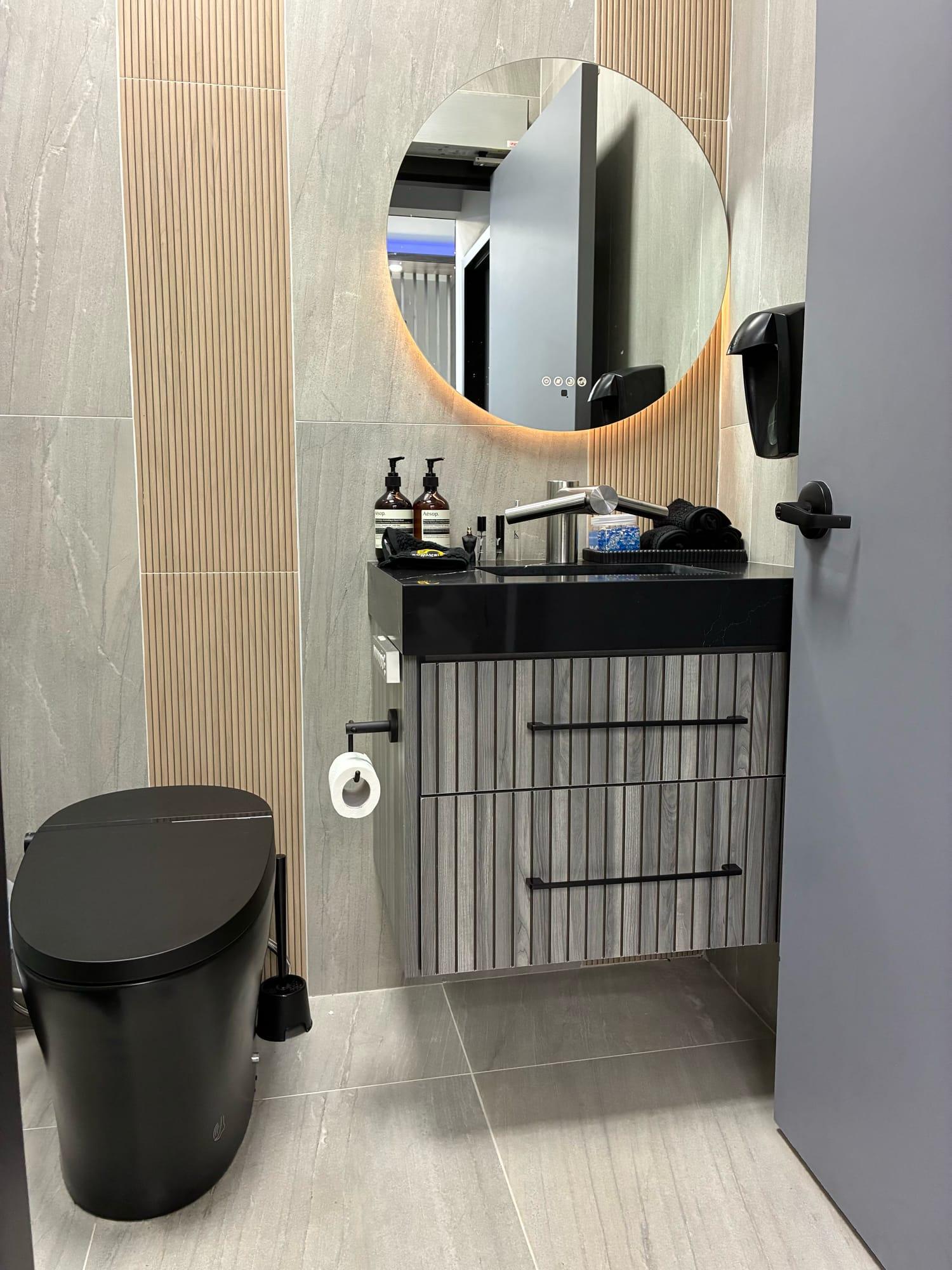 Washroom with a backlit round mirror